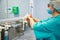 Female Surgeon in a medical mask and in a suit in the hospital washing thoroughly her hands before performing a surgery