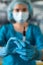 female surgeon uniform holds a syringe that will be administered to a patient in the operating