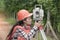 Female Surveyor or Engineer making measure by Theodolite on the street.