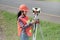 Female Surveyor or Engineer setting measure prism reflector on the street.