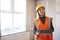 Female Surveyor In Hard Hat And High Visibility Jacket With Digital Tablet Carrying Out House Inspection