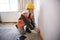 Female Surveyor In Hard Hat And High Visibility Jacket With Digital Tablet Carrying Out House Inspection