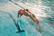 Female swimmer diving into indoor sports swimming pool