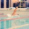 A female swimmer, that jumping and diving into indoor sport swimming pool. Sporty woman.