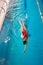 Female swimmer in swimsuit swimming on her back in pool