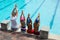 Female swimming instructor with students at pool side