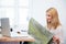 Female tailor holding cloth and looking on laptop screen