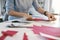 Female Tailor Making Sewing Patterns On Table