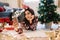 Female taking selfie near Christmas tree and gifts