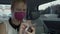 Female taxi passenger in mask surfing net on mobile