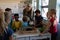 Female teacher around a box of plants for a nature study lesson in an elementary school classroom