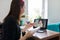 Female teacher at home with laptop on virtual meeting with teenage student