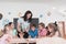 Female Teacher with kids in biology class at elementary school conducting biology or botanical scientific experiment