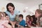 Female Teacher with kids in biology class at elementary school conducting biology or botanical scientific experiment