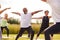 Female Teacher Leading Group Of Mature Men And Women In Class At Outdoor Yoga Retreat