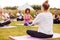 Female Teacher Leading Group Of Mature Men And Women In Class At Outdoor Yoga Retreat