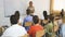 female teacher lecturing to students in auditorium