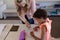 Female teacher with long blonde hair helping a schoolgirl in a classroom