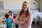 Female teacher with long blonde hair standing in a classroom