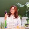 Female teacher looks at the chemical reaction of a reagent in a glass flask. Scientific experiments in a school chemistry class