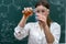 Female teacher mixing multi colored chemical liquids together during a chemistry lesson