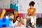 Female Teacher Reading Story To Group Of Elementary Pupils In School Classroom