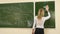 Female Teacher Rubbing off a Blackboard