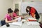 A female teacher teaching two girls in classroom at school