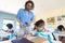 Female teacher wearing face mask teaching a boy in class at school