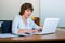 A female teacher works with a laptop in the classroom