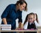 A female teacher yells at a student. Little girl covers her ears with her hands.