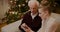 Female Teaching Grandfather To Use Cellphone In Christmas