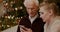 Female Teaching Grandfather To Use Cellphone In Christmas