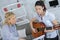 Female teaching young female to play guitar