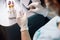 Female technician in latex gloves holds glass slide with transparent liquid drop at workplace