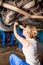 Female technician replaces the wheel of the vehicle in service