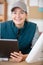 female technician at workbench holding digital tablet