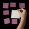 Female teen hand holding yellow sticky note agains pinks