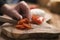 Female teen hand slicing cherry tomatoes with knife on wooden board