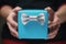 Female teen hands show blue paper gift box with gentleman bow