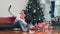 Female teen relax happy holding Gift and using smartphone selfie with Christmas tree enjoy xmas winter holidays.