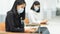 Female teenager college students wearing a face mask and keep distance while studying in classroom and college campus to prevent