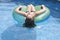Female teenager floating on float in pool