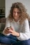 Female teenager sitting in a chair being busy with her digital p