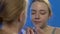 Female teenager squeezing acne, inappropriate skin care, hormone imbalance