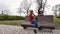 Female teenagers listening to music on smartphone sitting on the bench