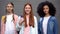 Female teenagers with school bags smiling on camera, student exchange program