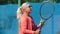 Female tennis coach serves balls using a racket