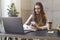 Female texting on smartphone during lunch break at workplace. Manager in office calling customers in front of laptop. Female using