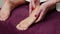 Female therapist doing revitalizing skin procedure of heels indoors